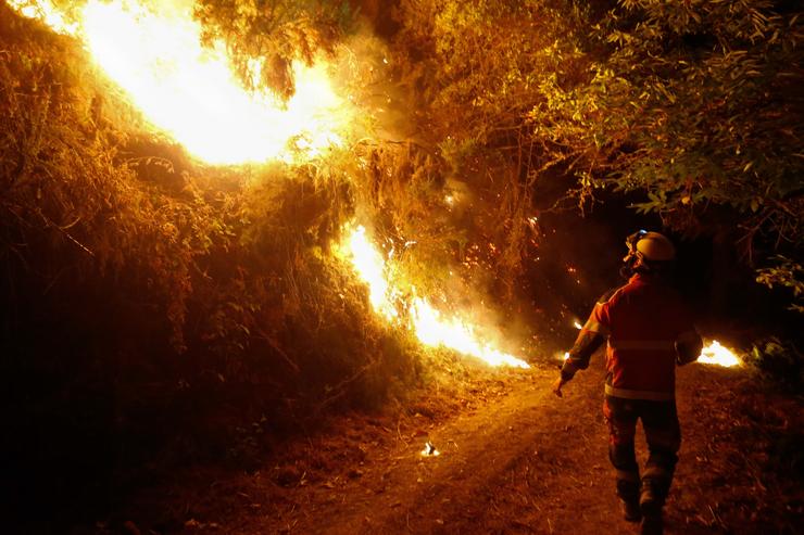 Un bombeiro traballa para a extinción do incendio 