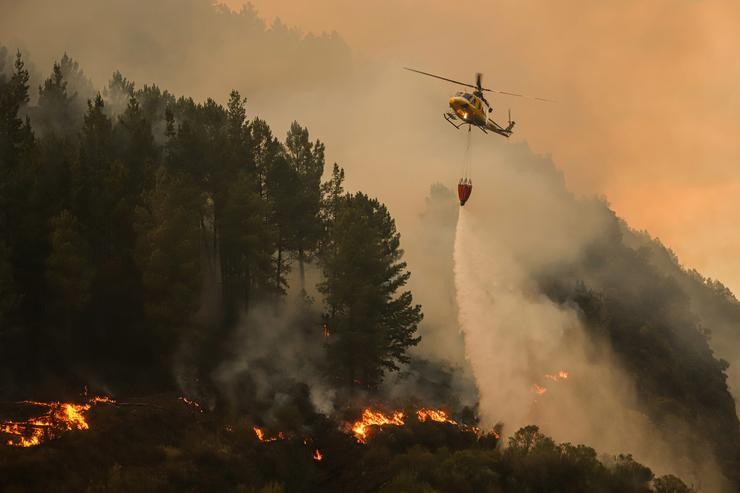 Un helicóptero solta auga sobre o lume.. Adrián Irago - Europa Press / Europa Press