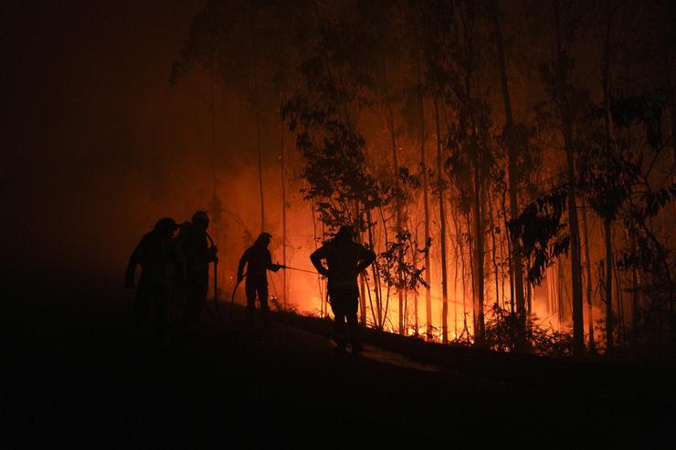 Varios bombeiros traballan para extinguir o lume na zona de Fonte de Faro de Brantuas, en Ponteceso. Gustavo da Paz - Europa Press 