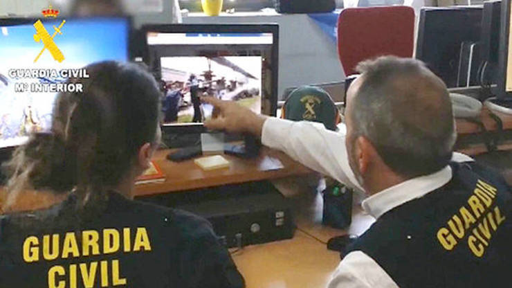 Axentes da Guardia Civil rastrexan as redes socias na Internet nun vídeo da operación Araña