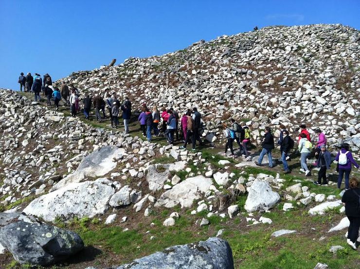 Un grupo de xente visita as escavacións do castro da Cabeciña, en Oia