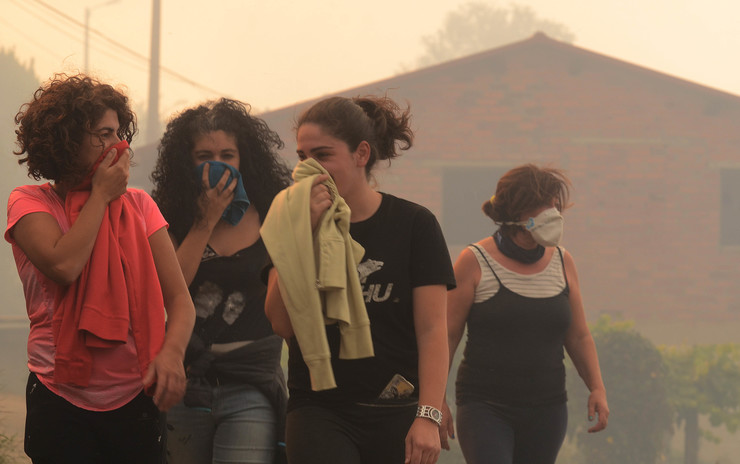 Mozas protéxense do fume e as cinzas en Pazos de Borbén, Veciños de Gondomar contemplan como o lume se achega ás súas casas, en plena onda de incendios en Galicia a mediados de outubro de 2017 