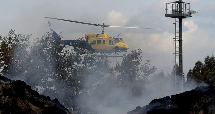 Un helicóptero sobrevoa o punto verde de Fragoselo, en Coruxo (Vigo), no que se atopa a planta de biomasa, totalmente arrasado polo lume da vaga de incendios que asolou Galicia en pleno mes de outubro 
