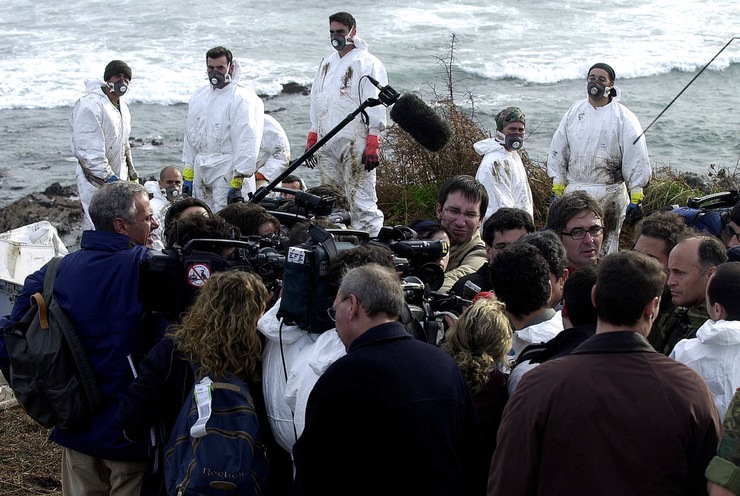 O por entón ministro de Defensa, Federico Trillo-Figueroa, na Illa de Ons en decembro de 2002, durante a marea negra do 'Prestige', arrodeado por numerosos reporteiros mentres os voluntarios que recollían o chapapote miraban atónitos a escena 