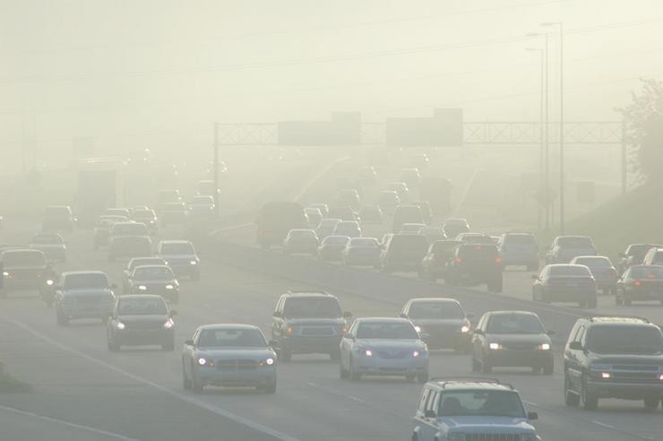 Unha densa capa de contaminación no aire apenas deixa ver o tráfico nunha autoestrada 