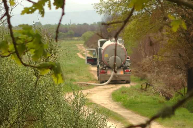 Camión de Coren descargando purin de granxas de polos nunha leira do Val da Limia 