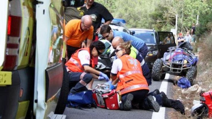 Persoal sanitario de Ambulancias atenden un ferido tras o accidente entre un coche e un quad 