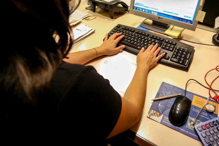Unha muller escribe no teclado do seu computador, no despacho da oficina.. Ricardo Rubio - Europa Press / Europa Press