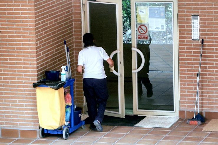 Unha traballadora da limpeza entra nun edificio co carriño da limpeza.. Ricardo Rubio - Europa Press / Europa Press
