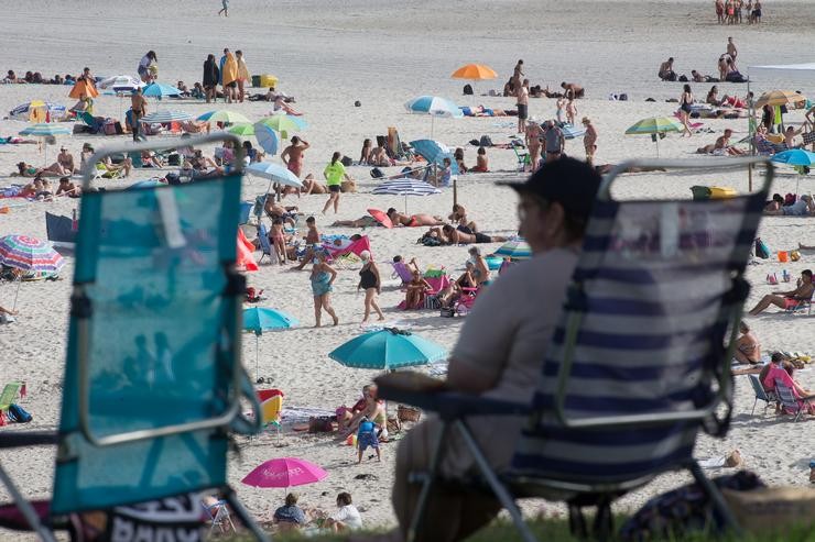 Unha persoa sentada fronte á praia na Mariña (Lugo/Galicia) a 27 de xullo de 2020. Carlos Castro - Europa Press - Arquivo / Europa Press