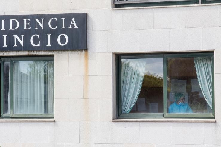 Unha sanitaria nunha xanela da residencia de anciáns do Incio, en Lugo / Carlos Castro - Europa Press - Arquivo