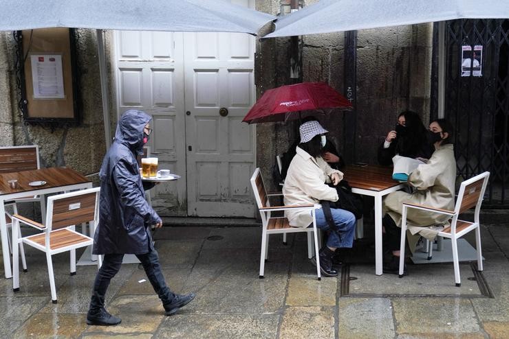 Unha camareira leva varias cervexas a unha das mesas da terraza do seu establecemento, en Santiago de Compostela, A Coruña (Galicia), a 22 de outubro de 2020.. Álvaro Ballesteros - Europa Press