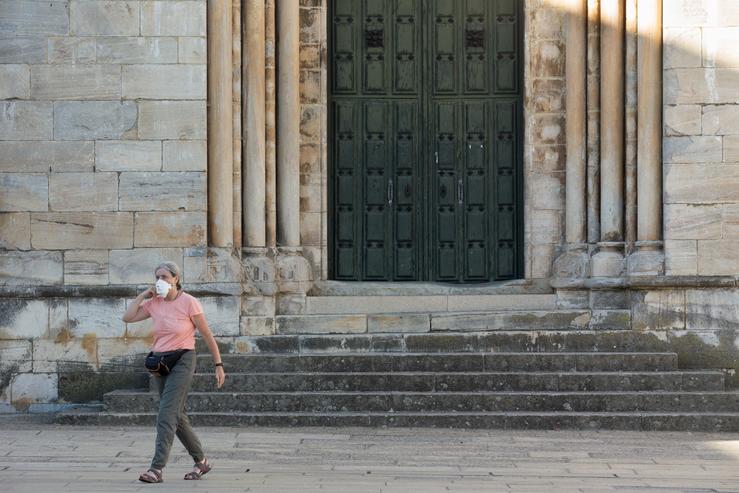 Unha peregrina xunto á Igrexa de San Nicolao mentres os peregrinos retornan ao Camiño francés da Ruta Xacobea case un mes despois do fin do estado de alarma polo coronavirus, en Portomarín. CARLOS CASTRO