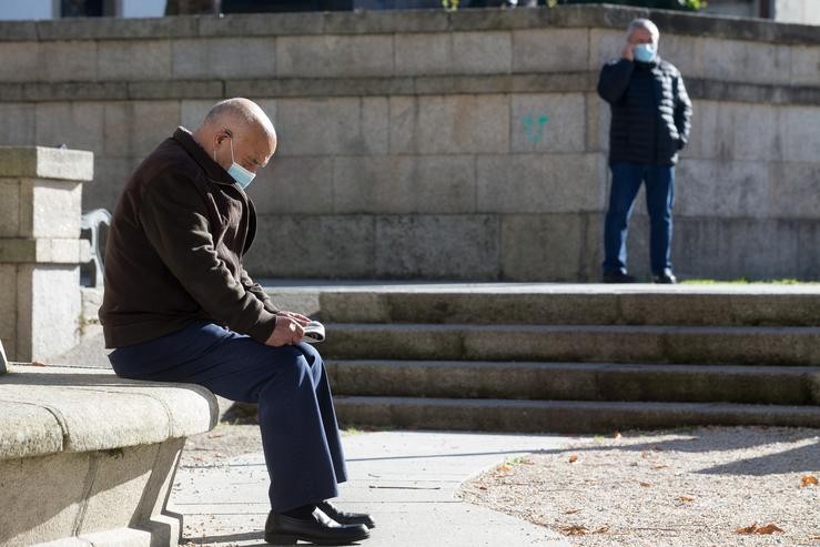 Unha persoa le nun banco o mesmo día da entrada en vigor de novas restricións impostas pola crise do Covid-19 no municipio de Vilalba, Lugo, (España), a 21 de novembro de 2020. Entre as medidas, ademais do peche perimetral, inclúese. Carlos Castro - Europa Press 