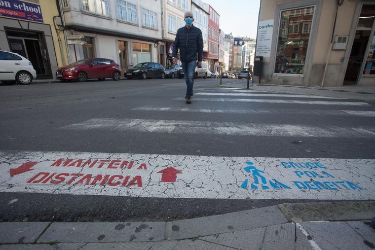 Unha persoa cruza un paso de peóns o mesmo día da entrada en vigor de novas restricións impostas pola crise do Covid-19 no municipio de Vilalba, Lugo, (España), a 21 de novembro de 2020. Entre as medidas, ademais do peche perimetral, se. Carlos Castro - Europa Press 