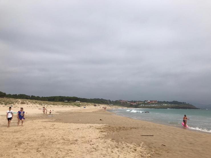 Persoas na praia nun día anubrado 