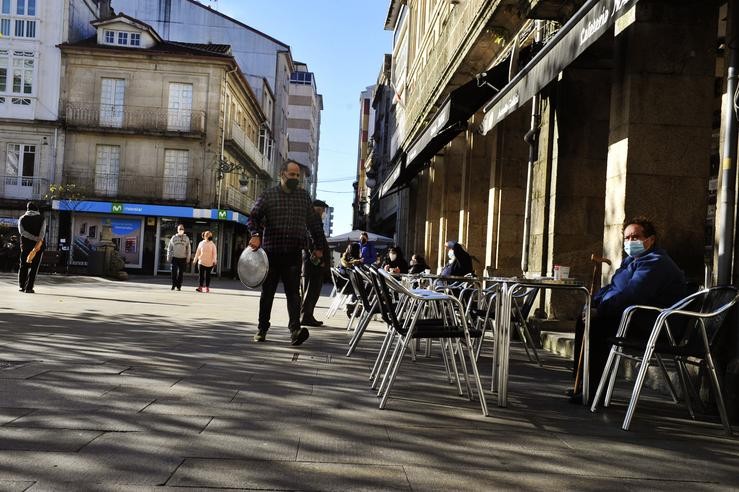 Comensais sentados nunha terraza dun establecemento aberto no Carballiño tras levantarse o peche perimetral e reabrir a hostalaría 