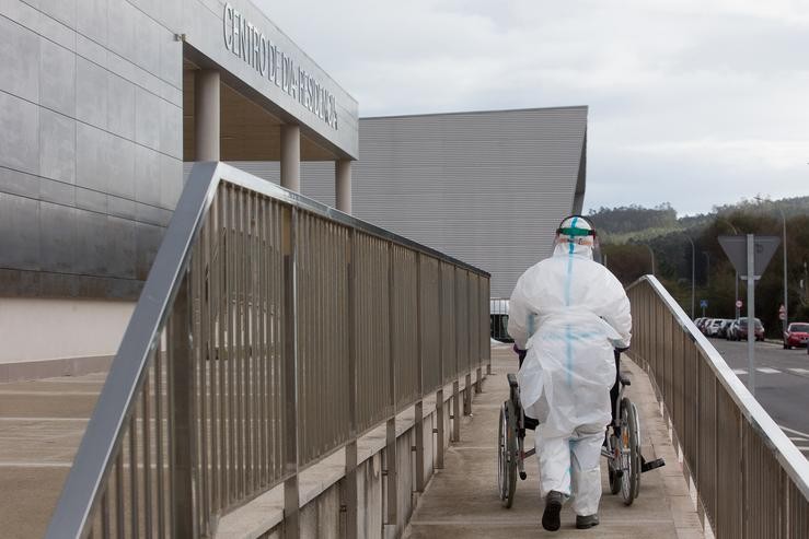 Un traballador sanitario totalmente protexido acoden a buscar a un ancián da residencia de anciáns de San Cibrao onde se orixinou un brote de Covid-19, en San Cibrao, Lugo, Galicia, (España), a 9 de novembro de 2020. No centro a situación ac. Carlos Castro - Europa Press