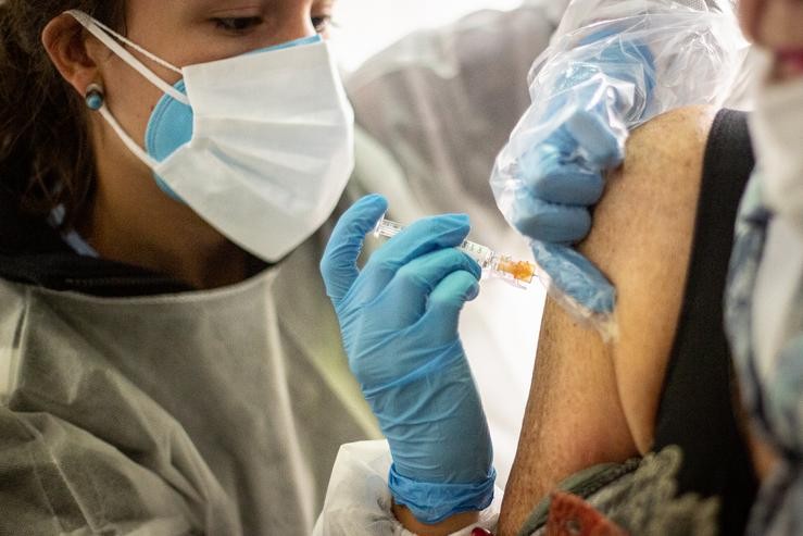 Unha enfermeira inxecta a vacina contra a gripe a un paciente no recinto habilitado no Iradier Area, en Vitoria, Áraba, País Vasco, (España), a 13 de outubro de 2020. Baixo a lema 