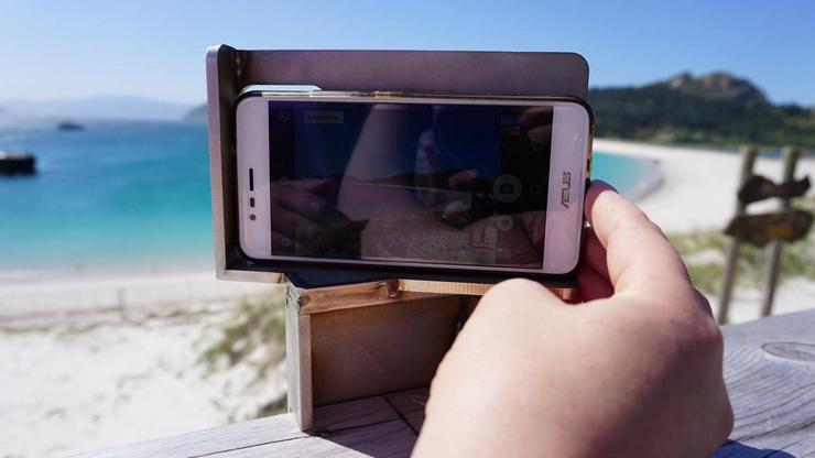 Un visitante toma unha fotografía co seu teléfono móbil na praia. UNIVERSIDADE DE VIGO