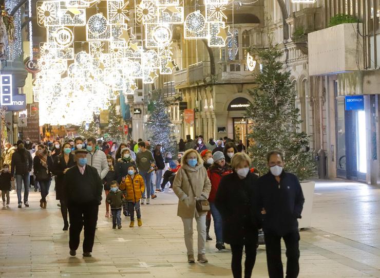 Transeúntes pasean baixo as luces do Nadal, levando máscara, en Vigo, Galicia (España), a 25 de decembro de 2020. Vigo está pechada perimetralmente, pero aberta entre o 23 e 25 de decembro para permitir encontros familiares.. Marta Vázquez Rodríguez - Europa Press / Europa Press