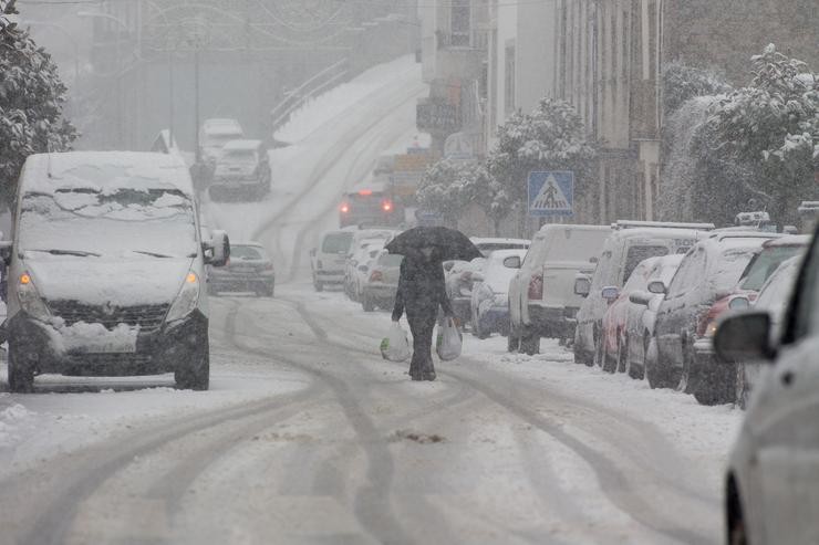 Un home camiña no medio dunha gran nevada en Becerrea, en Lugo 