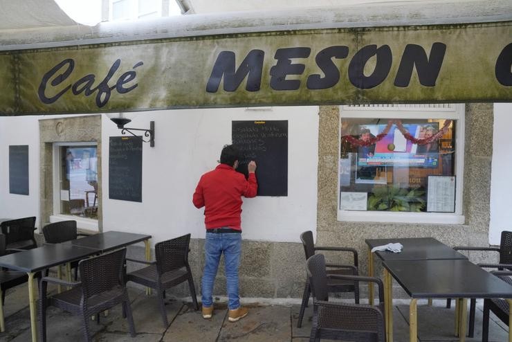 Un home escribe na lousa dun mesón, en Santiago de Compostela, A Coruña, Galicia (España), a 4 de decembro de 2020. Hoxe reábrese a hostalaría en toda Galicia, aínda que en distinto grao en función dos datos dos contagios de coronavirus, e. Álvaro Ballesteros - Europa Press 