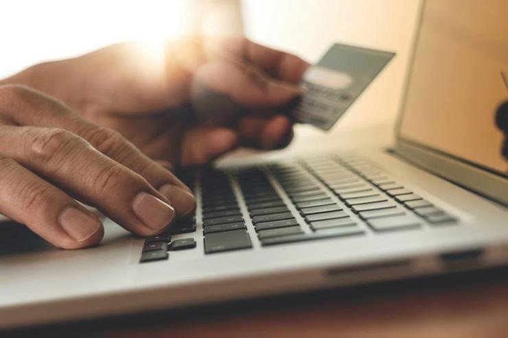 Persoa usando un computador con cartón de crédito e facendo compras en liña. NIELSEN - Arquivo / Europa Press
