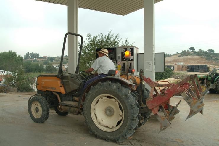 Tractor antigo nunha gasolineira. UNIUNA DE LLAURADORS - Arquivo