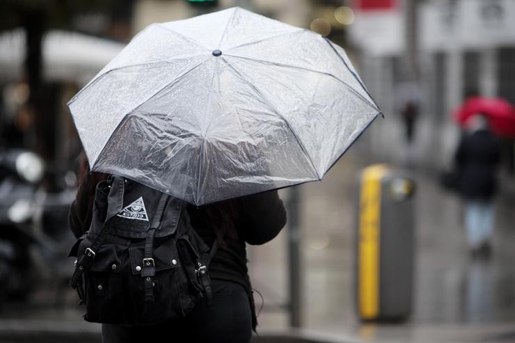 Unha persoa pasea con paraugas para protexerse da borrasca `Gloria´ / Europa Press