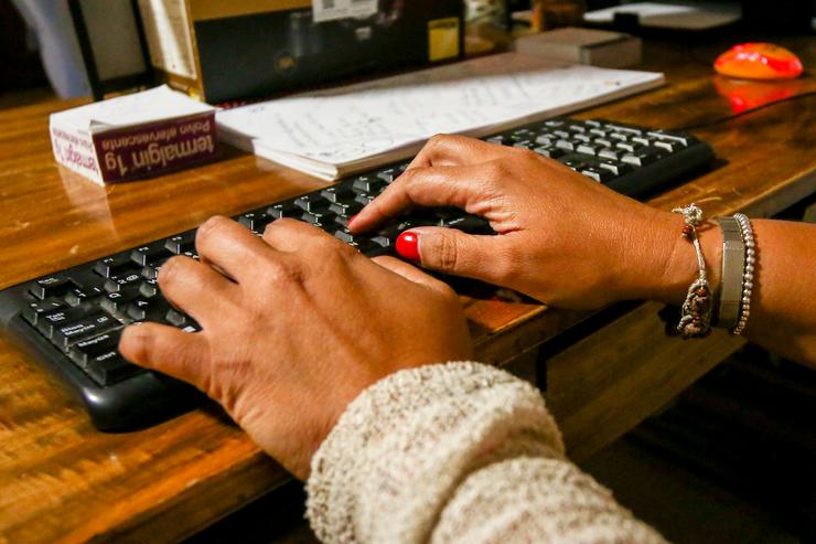 Unhas mans de muller escriben no teclado dun computador, sobre unha mesa de madeira.. Ricardo Rubio - Europa Press - Arquivo