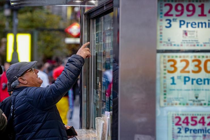 Un home sinala o décimo de Lotaría de Nadal que quere comprar nunha Administración na praza de Porta do Sol, en Madrid (España), a 18 de novembro de 2019.. Ricardo Rubio - Europa Press - Arquivo 