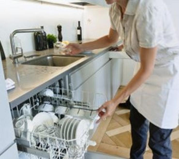 Empregada do fogar nun servizo domestico cun lavalouzas. CCOO/UGT - Arquivo
