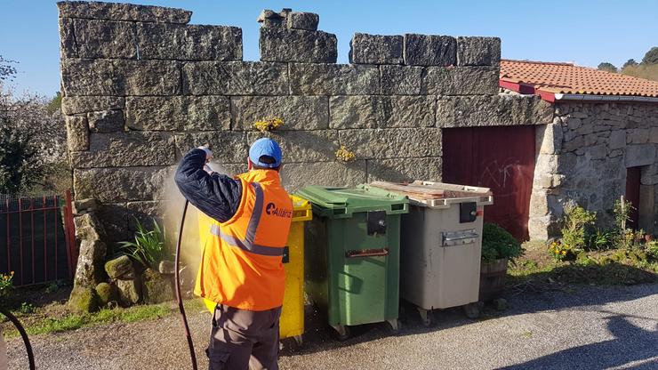 Traballadores municipais desinfectando contedores 