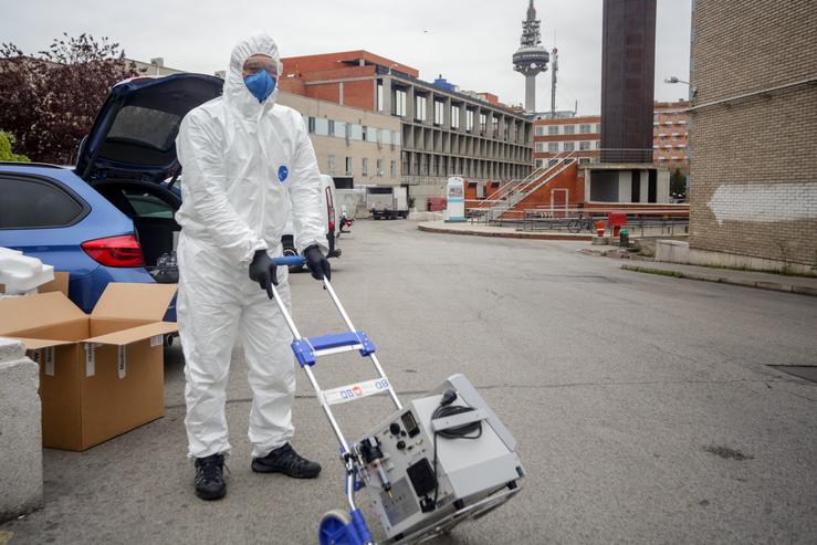 Un técnico protexido cun traxe, luvas e máscara 