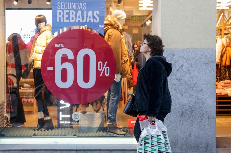 Unha muller pasea xunto a unha tenda de moda de Madrid, na que se ofertan as segundas rebaixas con ofertas de ata o 60  Ricardo Rubio - Europa Press - Arquivo