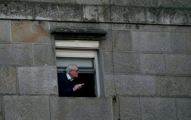 Un home mira pola ventá durante o confinamento / © Miguel Núñez