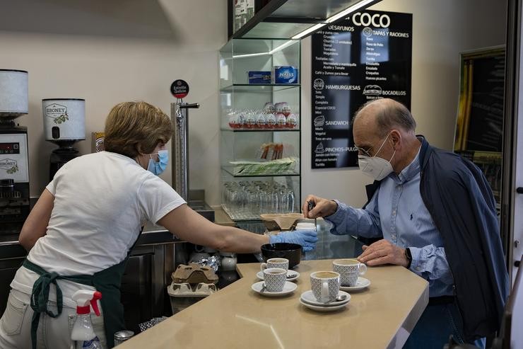 Un home toma un café nun bar da capital da Coruña, o día que no que a provincia pasa xunto a Pontevedra, Luego e Ourense á Fase 1 do Plan de Desescalada establecido polo Goberno de España 