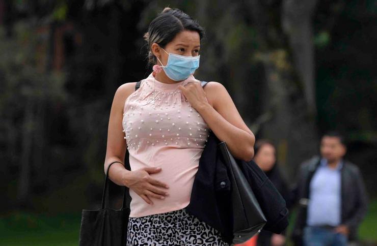 Unha muller embarazada protéxese da Covid-19 cunha máscara  / RAUL ARBOLEDA/AFP vía Getty Images)
