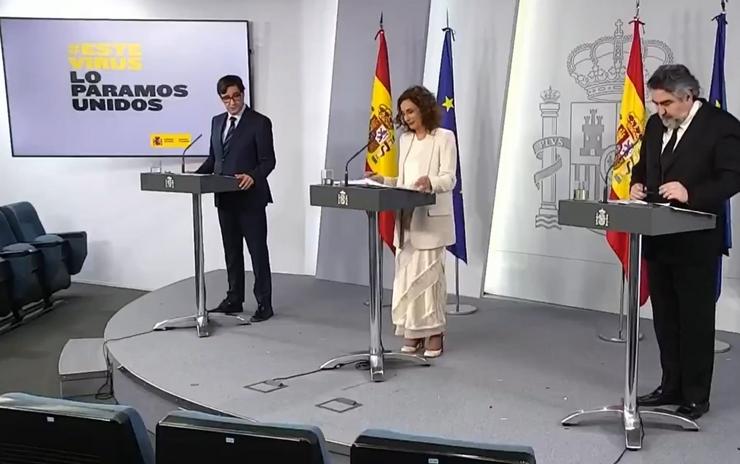 A portavoz do Goberno e ministra de Facenda, María Jesús Montero, o ministro de Sanidade, Salvador Illa, e o ministro de Cultura e Deporte, José Manuel Rodriguez Uribes, na rolda de prensa telemática tras o consello de ministros. MONCLOA 