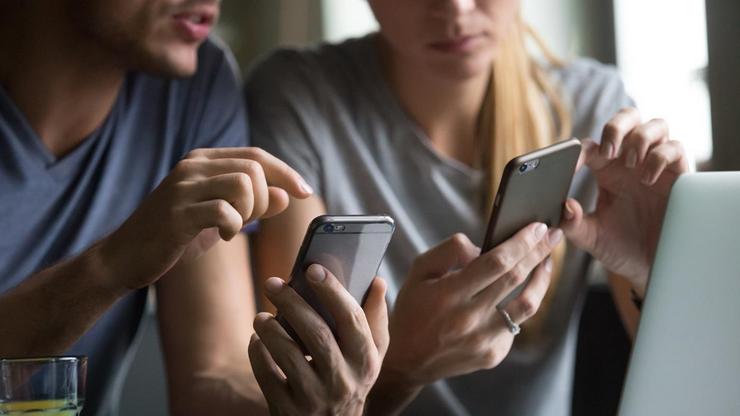 Dúas persoas utilizan os seus teléfonos móbiles. Foto: UNIVERSIDADE DE VIGO