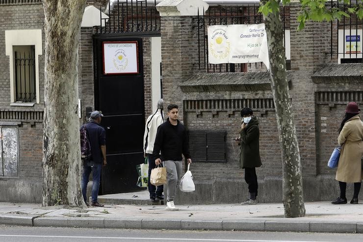 Decenas de persoas esperan na cola ás portas do Comedor Social María Inmaculada da capital para recoller alimentos e produtos de primeira necesidade en plena pandemia do Covid-19, durante o primeiro día en que os españois poden saír de casa. Josefina Branco - Europa Press / Europa Press