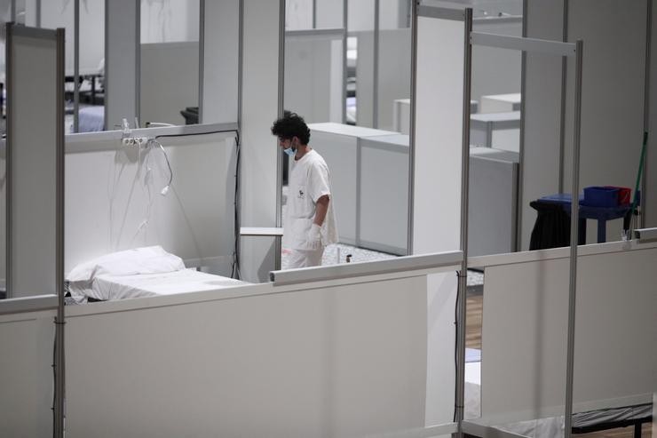 Un profesional sanitario fronte a unha cama baleira no interior do hospital de campaña de IFEMA durante o seu último día de funcionamento pola baixada da presión asistencial. En Madrid (España) a 30 de abril de 2020.. Eduardo Parra - Europa Press - Arquivo 