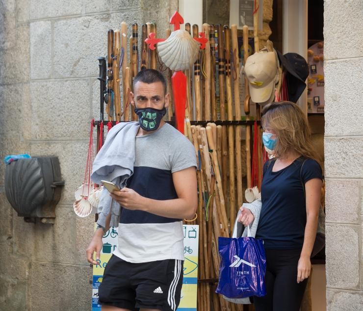 Os peregrinos alacantinos Miguel Anxo e Elena saen dun establecemento con elementos do Camiño á venda na localidade de Sarria, mentres os peregrinos retornan ao Camiño francés da Ruta Xacobea. Carlos Castro - Europa Press 