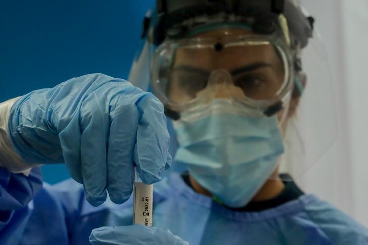 Unha traballadora sanitaria sostén unha probeta cunha proba PCR / Ricardo Rubio - Europa Press.