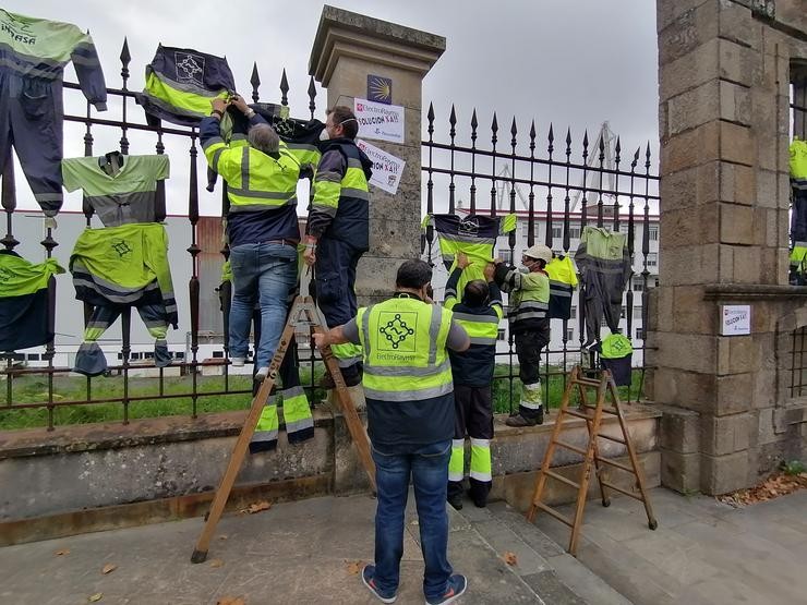 Ogperarios de ElectroRayma colgando a súa roupa de traballo do enreixado de Navantia Ferrol. 