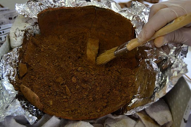 Traballos de recuperación dos restos óseos dentro da pota de cerámica atopada en 