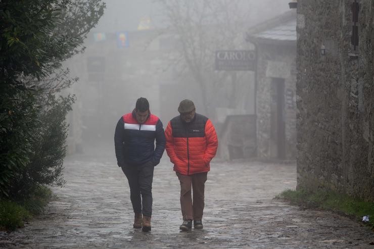 Dous homes camiñan entre a néboa na aldea prerromana de Ou Cebreiro, Concello de Pedrafita do Cebreiro, Lugo, Galicia (España). A Montaña lucense rexistrou as primeiras nevadas nas  zonas máis altas de Cervantes e Pedrafita (Lugo), onde han ll. Carlos Castro - Europa Press 