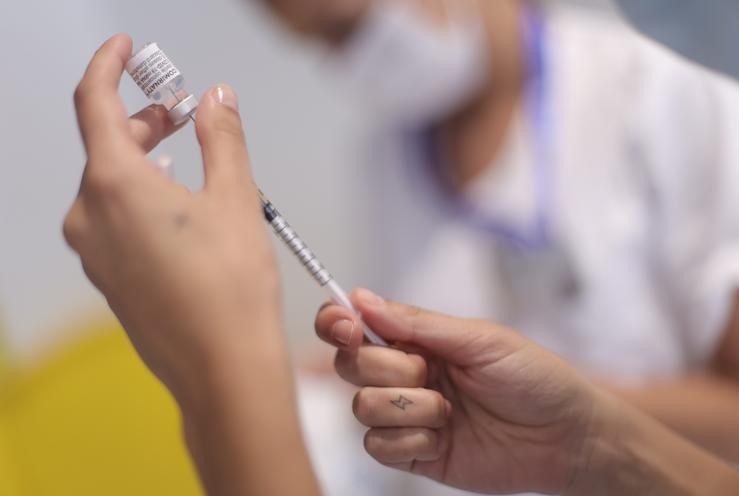Unha sanitaria recarga unha dose da vacina contra o Covid-19 