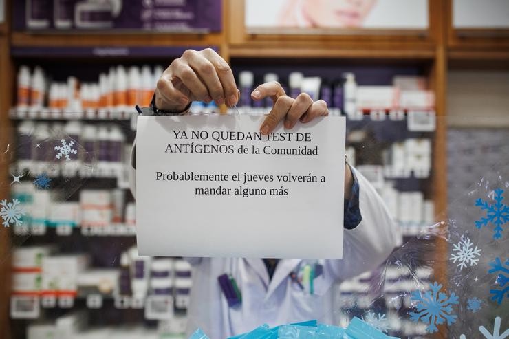 O farmacéutico colga o cartel de que o test de antígenos da Comunidade de Madrid están esgotados na farmacia da Rúa Tucán, no distrito de Carabanchel, a 21 de decembro de 2021, en Madrid (España).. Alejandro Martínez Vélez - Europa Press 